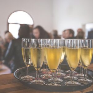 A sophisticated event with champagne glasses at a lively social gathering indoors.